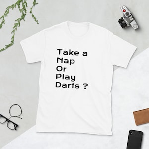 Puede incluir: Camiseta blanca con texto negro que dice "Take a Nap Or Play Darts?"