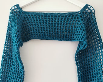 Op de afbeelding: Turquoise blauwe gehaakte top met lange mouwen en een open halslijn. De top is gemaakt van een lichtgewicht, opengeweven stof.