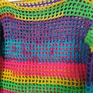Op de afbeelding: Een regenboog-crochet top met een kleurrijk gestreept patroon. De top is gemaakt van een lichtgewicht, opengeweven stof.