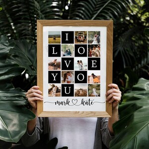 May include: A framed photo collage with 16 photos arranged in a grid, spelling out "I LOVE YOU". The photos are of a couple in various settings, including a field, a forest, and a beach. The frame is made of wood and has a white mount. The names "mark" and "kate" are written below the collage, with a heart symbol between them.