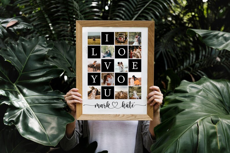 May include: A framed photo collage with 16 photos arranged in a grid, spelling out "I LOVE YOU". The photos are of a couple in various settings, including a field, a forest, and a beach. The frame is made of wood and has a white mount. The names "mark" and "kate" are written below the collage, with a heart symbol between them.