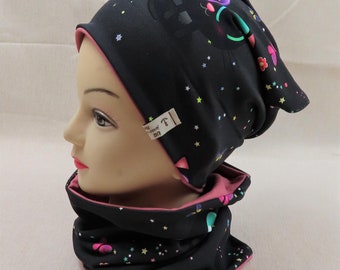 May include: Black and pink reversible beanie with a black cat and stars print. The beanie has a pink seam and a small white label with the text "Lue Made with Love".