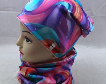 May include: A colorful beanie and neck gaiter set. The fabric features a swirling pattern of pink, purple, blue, and orange. The beanie has small, silver-colored embellishments. The neck gaiter is a matching tube scarf.