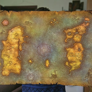 Pu&ograve; includere: Una mappa in stile vintage del mondo immaginario di Azeroth dal videogioco World of Warcraft. La mappa mostra i continenti di Kalimdor e dei Regni Orientali, con un vortice vorticoso al centro.