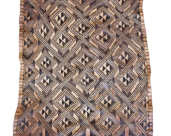 May include: A woven textile with a repeating geometric pattern of diamonds and triangles in shades of brown, black, and beige. The edges are finished with a textured border. The textile is likely handmade.