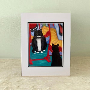 Könnte beinhalten: Eine schwarz-weiße Katze mit gelben Augen schaut in einen Spiegel. Der Spiegel ist von bunten abstrakten Formen umgeben. Eine zweite schwarze Katze spiegelt sich im Spiegel.