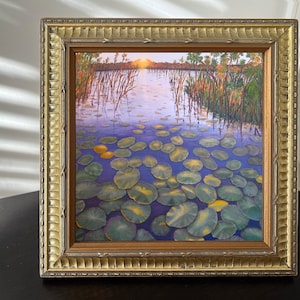 Näckrosor i floden, inramat signerat tryck. Solen går ner över Okavangodeltat, Sydafrika.