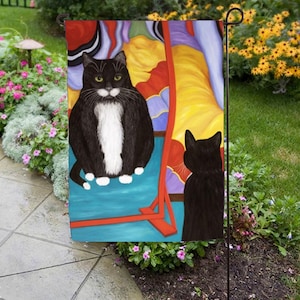 May include: A black and white cat with white paws sits in front of a colorful abstract painting. The cat is looking at its reflection in the painting, which is also a black and white cat.