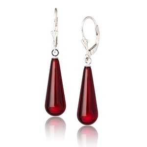 May include: A pair of silver dangle earrings with teardrop-shaped red amber stones.