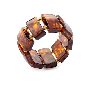May include: A brown amber bracelet with gold accents. The bracelet is made of rectangular amber beads that are connected by gold spacers.
