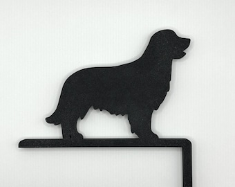 May include: Black metal silhouette of a golden retriever dog standing on a metal hook. The hook is designed to be attached to a fence or mailbox.