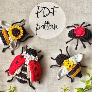 May include: Four crocheted insect figures including a ladybug with white flowers, a bee with a sunflower, a bee with yellow flowers, and a black beetle with a red rose. The text PDF pattern is centred above the figures on a light fabric background.