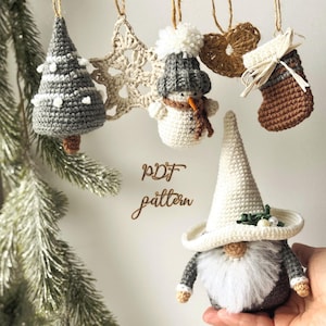 Könnte beinhalten: Handgefertigte gehäkelte Weihnachtsschmuckstücke, darunter ein Baum, ein Stern, ein Schneemann, ein Herz und ein Strumpf. Die Ornamente sind in neutralen Farben mit braunen und weißen Akzenten gehalten. Der Text "PDF pattern" ist sichtbar.