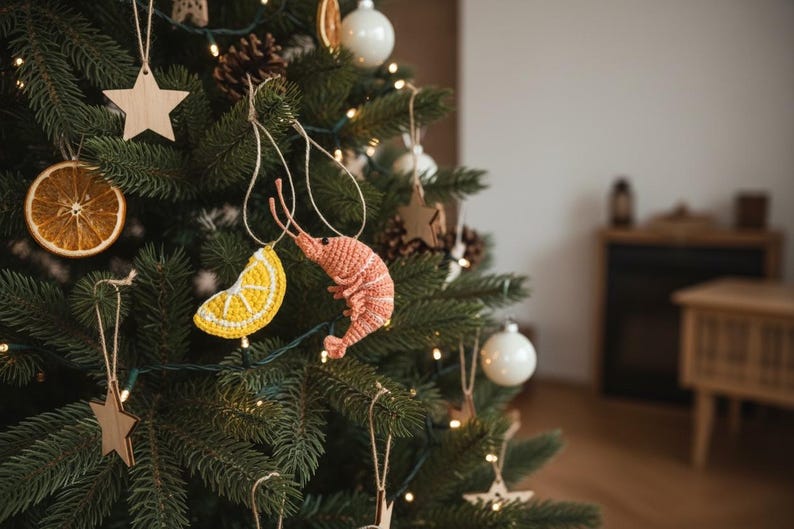 May include: A decorated Christmas tree with various ornaments. The tree features a dried orange slice, wooden star, white ball ornaments, and crocheted shrimp and lemon slice ornaments. The tree is lit with small white lights.