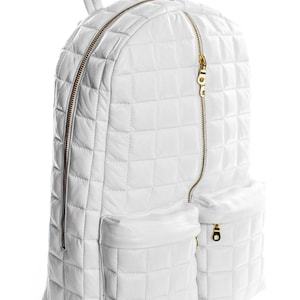 May include: A white quilted leather backpack with gold zips and two front pockets.