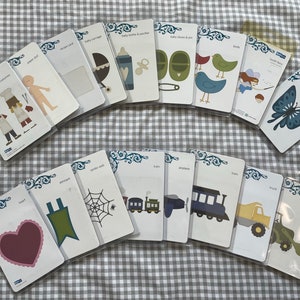 May include: A set of 16 die-cut cardstock shapes for crafting. The shapes include a butterfly, a spider web, a heart, a train, a truck, a plane, a fairy, a baby bottle, a baby shoe, a chef, a paper doll, a banner, and more.