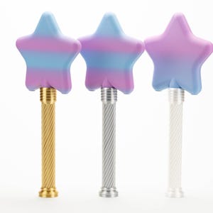 Peut inclure: Trois baguettes en forme d'&eacute;toile avec des d&eacute;grad&eacute;s de couleurs pastel bleu, violet et rose. Les baguettes ont des manches en m&eacute;tal torsad&eacute; en or, argent et blanc. Les baguettes sont sur fond blanc.