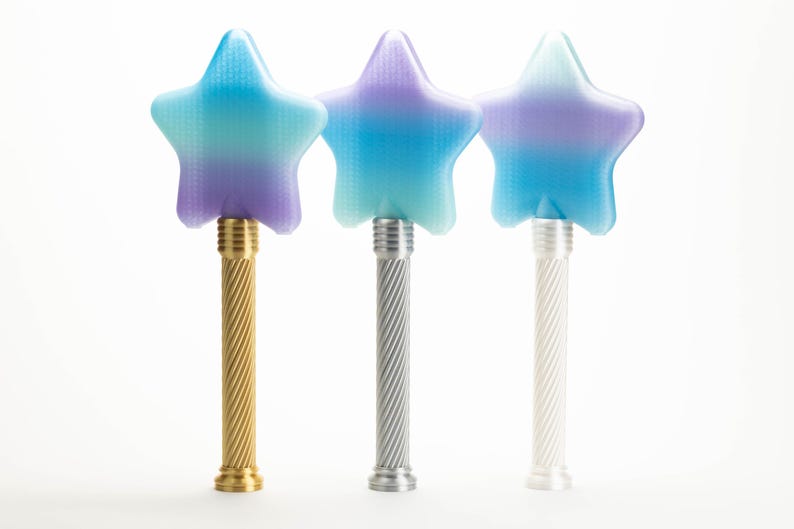 Peut inclure: Trois baguettes magiques en forme d'&eacute;toile avec des sommets d&eacute;grad&eacute;s bleus et violets. Les baguettes ont des manches m&eacute;talliques dor&eacute;s, argent&eacute;s et blancs. Les manches ont un design en spirale. Sur fond blanc.