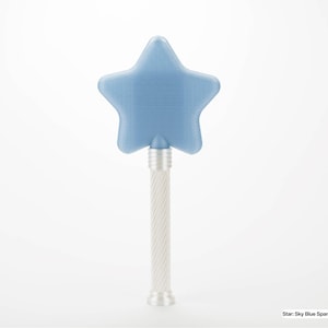 Peut inclure: Une baguette en forme d'&eacute;toile bleu ciel avec un manche perl&eacute;. L'&eacute;toile est de couleur bleu translucide. Le manche est argent&eacute; avec un motif torsad&eacute;. Le texte en bas indique : Star: Sky Blue Sparkle (Translucent) Staff: Pearl.