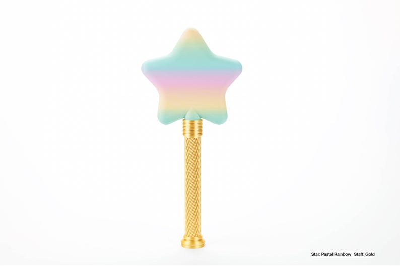 Peut inclure: Une baguette magique en forme d'&eacute;toile avec un motif arc-en-ciel pastel et un manche dor&eacute;. L'&eacute;toile de la baguette pr&eacute;sente un d&eacute;grad&eacute; de couleurs, dont le bleu, le rose et le jaune. La poign&eacute;e a un design torsad&eacute;. Le texte en bas dit "Star: Pastel Rainbow Staff: Gold".