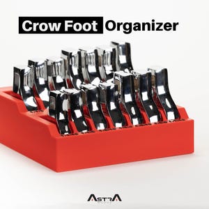 Puede incluir: Un organizador rojo que contiene varias llaves de pata de cuervo cromadas. El texto "Crow Foot Organizer" se muestra en negro en la parte superior. La marca "ASTRA" es visible en la parte inferior.
