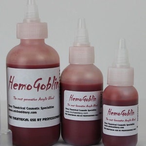 May include: Three bottles of Hemo Goblin theatrical acrylic blood. The bottles are various sizes, filled with a deep red liquid, and have white labels with black text. The bottles have white tops and are for theatrical use.