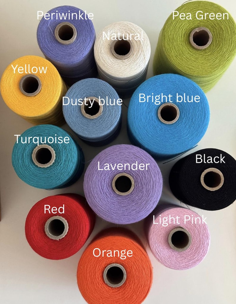 Pode incluir: Uma cole&ccedil;&atilde;o de bobinas de fios coloridos em v&aacute;rias tonalidades, incluindo azul-celeste, amarelo, turquesa, vermelho, laranja e preto. A imagem tamb&eacute;m mostra fios naturais, verde-ervilha, azul empoeirado, azul brilhante, lavanda e rosa claro. Cada bobina &eacute; rotulada com o nome da sua cor.