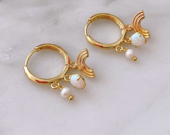 May include: Gold hoop earrings with a rainbow charm and a white opal and pearl dangle.