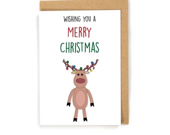 May include: A white card with a brown envelope. The card has a cartoon reindeer with Christmas lights on its antlers. The text on the card reads "Wishing you a Merry Christmas".