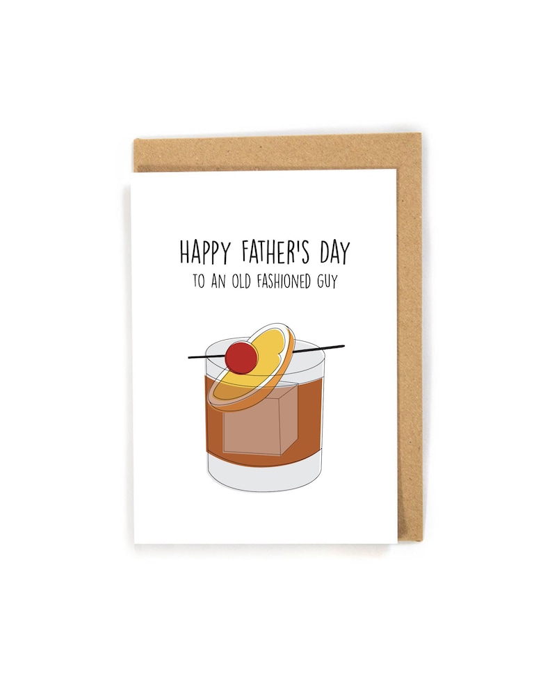 K&ouml;nnte beinhalten: Eine wei&szlig;e Karte mit schwarzem Text, der "Happy Father's Day to an Old Fashioned Guy" lautet. Unter dem Text befindet sich eine Illustration eines Old Fashioned Cocktails mit einer Kirsche und einer Orangenscheibe.