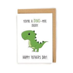 May include: A white card with a green dinosaur illustration and the text "You're a Dino-mite Daddy Happy Father's Day!"