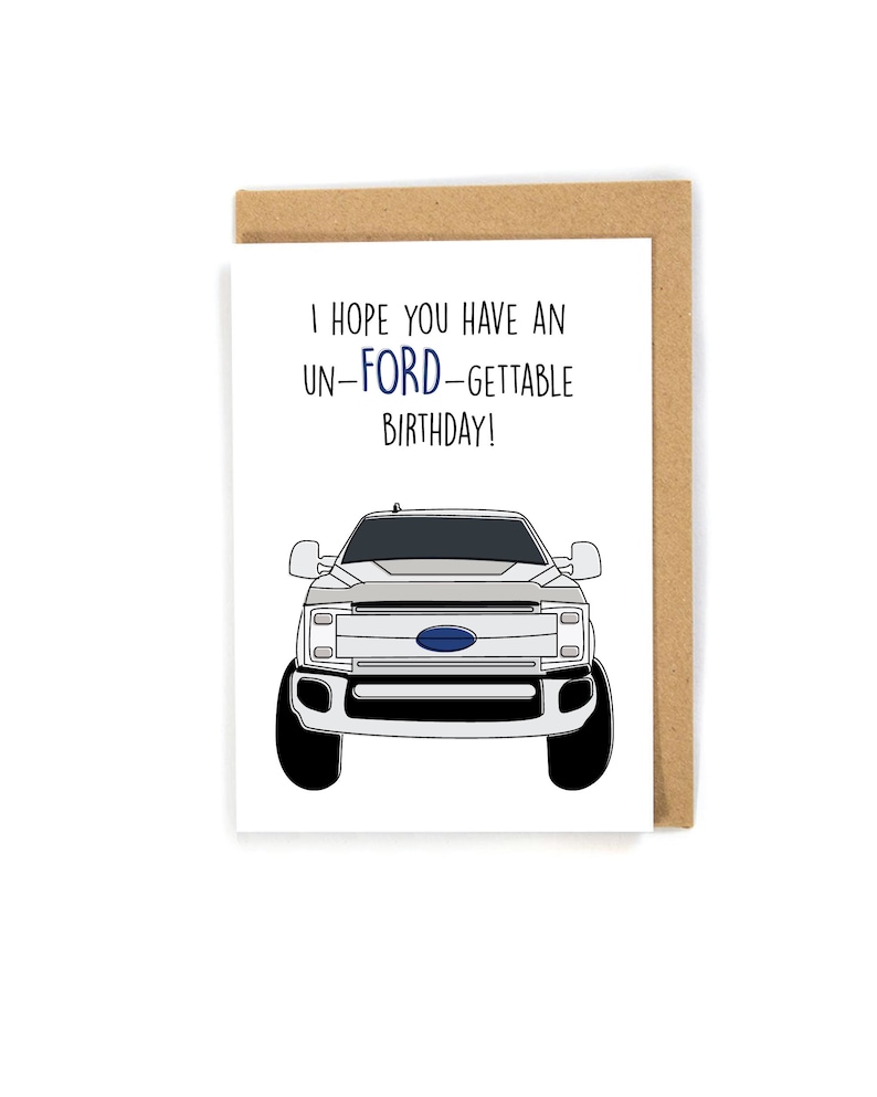 May include: A white greeting card with a cartoon illustration of a white Ford pickup truck. The text on the card reads "I hope you have an un-Ford-gettable birthday!"