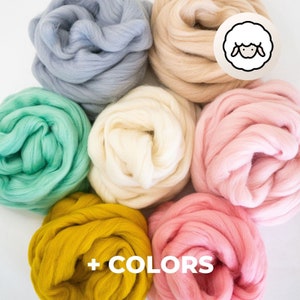 Puede incluir: Seis ovillos de lana de diferentes colores: azul claro, verde, blanco, rosa, rosa claro y amarillo. La lana está dispuesta en círculo con los colores alternando.