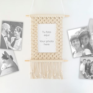 May include: A macrame wall hanging with a white frame and a white card that says "Tu foto aqui - Your photo here". The wall hanging is surrounded by black and white photos.
