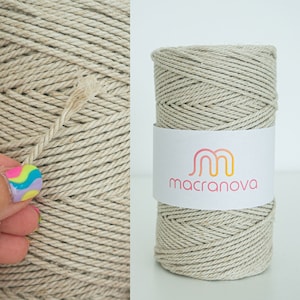 May include: A spool of natural coloured cotton rope with a white label that says "macranova" in a stylised font.