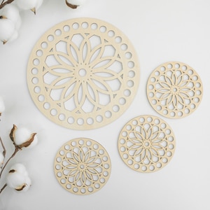 Op de afbeelding: Drie ronde houten haakdoilies met een decoratief bloemmotief. De doilies zijn in verschillende maten en zijn gerangschikt op een wit oppervlak.