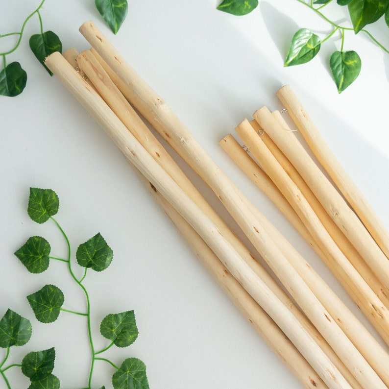 May include: A set of natural wood dowels, bundled together, for crafting projects. The dowels are smooth and light brown in color.