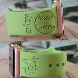 May include: A green Apple Watch band with a baseball and the name "Kayla" engraved on it. The band is shown on a rose gold Apple Watch.