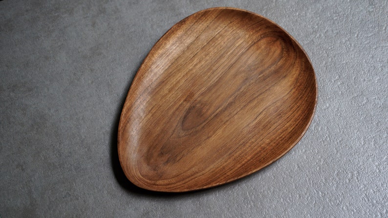 May include: A wooden serving tray with a natural wood finish and an oval shape.