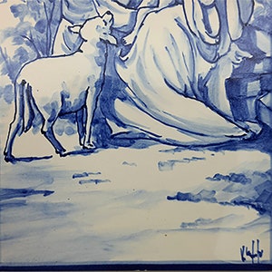 May include: A hand-painted ceramic tile featuring a woman, a child, and a lamb, all depicted in blue and white. The woman is wearing a long flowing robe and the child is sitting on her lap. The lamb is standing in front of them. The tile is bordered in blue.