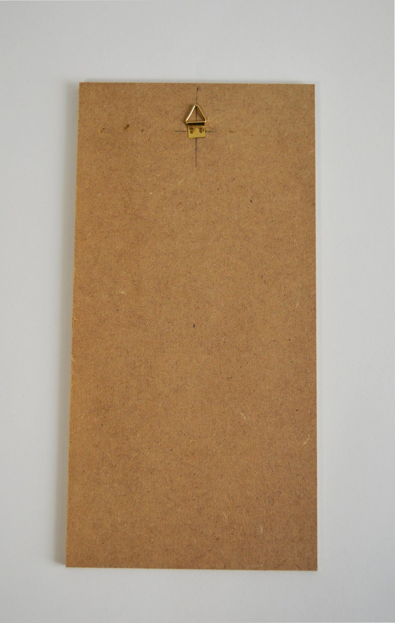 May include: A brown rectangular piece of wood with a gold-coloured hanging hook attached to the top.