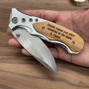 May include: A silver pocket knife with a wooden handle. The handle has an engraved message that reads "Finally found you after roaming in the dark R. Cantu".