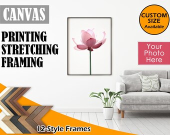May include: A white wall with a framed canvas print of a pink lotus flower. The canvas is available in custom sizes. The text "CANVAS" is in large, bold, grey letters. Below the text are three checkmarks with the text "PRINTING", "STRETCHING", and "FRAMING". Below the canvas is a grey sofa with a white throw pillow and a green plant in a white pot. The text "12-Style Frames" is below the plant. A white frame with the text "Your Photo Here" is on the wall above the sofa. A yellow circle with the text "CUSTOM SIZE Available" is on the wall to the right of the frame.