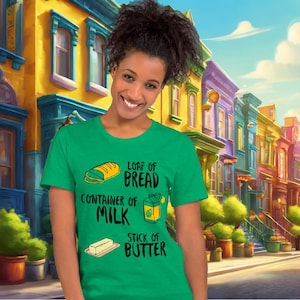 Puede incluir: Una camiseta verde con un gráfico blanco de una barra de pan, un recipiente de leche y una barra de mantequilla. El texto en la camiseta dice "Loaf of Bread", "Container of Milk" y "Stick of Butter".
