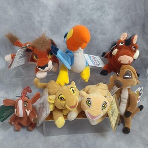May include: A collection of plush toys featuring characters from Disney's The Lion King. The toys include Simba, Nala, Timon, Pumbaa, Zazu, Scar, and Rafiki. Each plush toy has a tag attached.