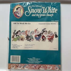 Może przedstawiać: Zestaw do haftu krzyżykowego z motywem Królewny Śnieżki i siedmiu krasnoludków. Opakowanie zawiera ilustrację Królewny Śnieżki i siedmiu krasnoludków. Wyświetlany jest tekst "Off To Work We Go". Rozmiar gotowego wzoru to 14 x 40.6 cm.