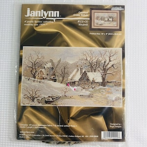 Op de afbeelding: Een geteld kruissteekpatroon met een winterscène met een windmolen, huizen en bomen. Het patroon heeft de titel "Windmill" en is van Janlynn, een familiebedrijf dat creativiteit ontketent sinds 1979. De afgewerkte maat is 12 inch bij 8 inch (30,5 cm bij 22,9 cm).