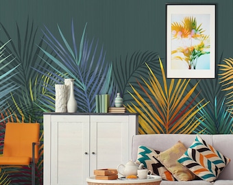 以下が含まれることがあります： 白いソファ、壁に掛けられた2つの額縁に入った絵画、白いキャビネット、籐製のコーヒーテーブル、籐製のオットマンがあるリビングルームのインテリアデザイン。壁は緑、青、黄色の熱帯の葉の壁紙で覆われています。