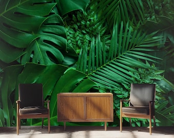 May include: Two black chairs and a wooden cabinet with two doors are placed in front of a wall covered in a green tropical leaf wallpaper.