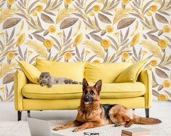 Puede incluir: Un sofá amarillo con un gato gris y un perro pastor alemán marrón y negro sentados en él. El sofá está frente a una pared con un patrón floral en tonos amarillos y grises.